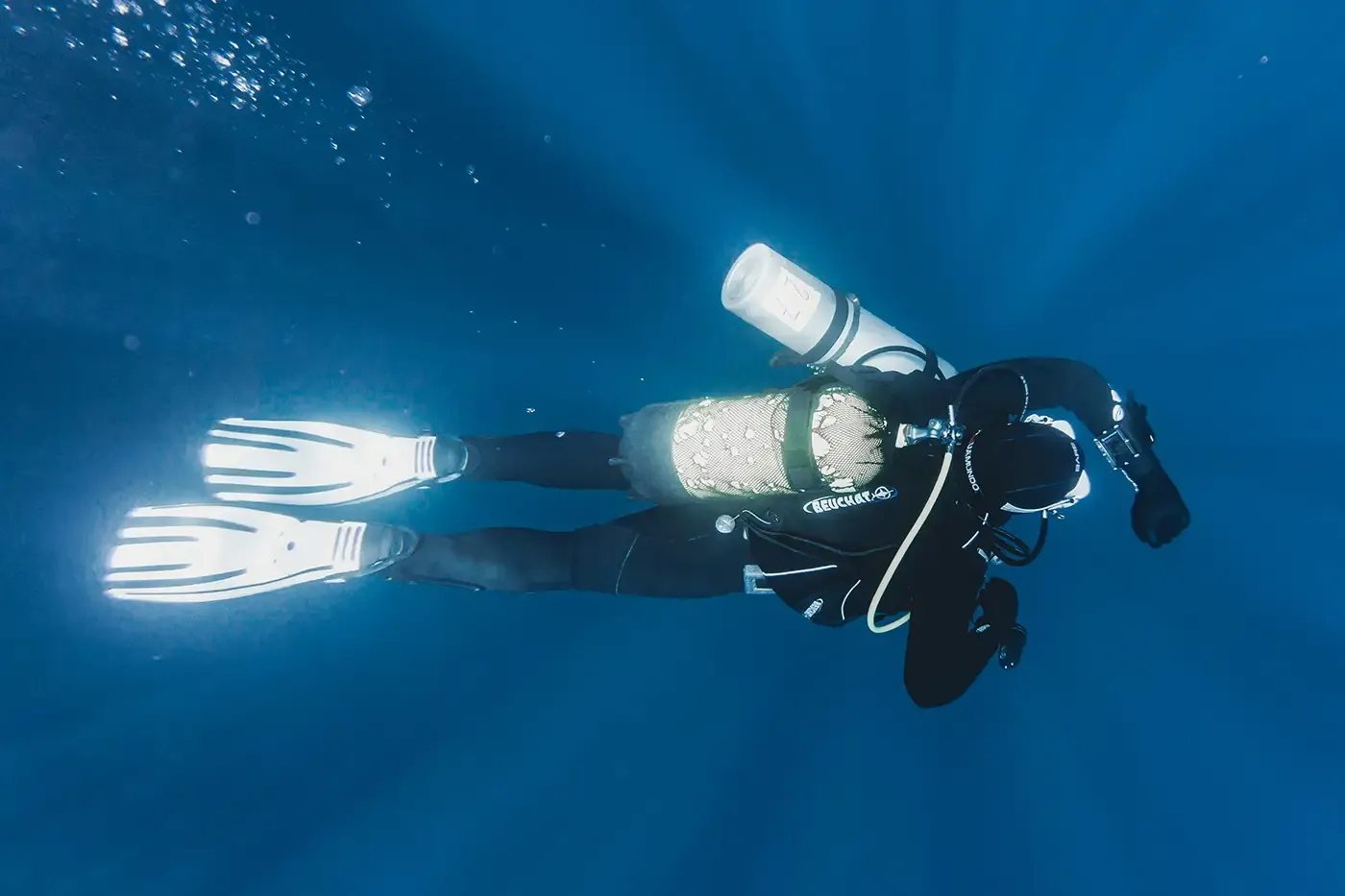 Scuba diver underwater using a compact composite breathing air tank, representing Steelhead’s lightweight, DOT-compliant COPVs for portable gas storage in life-support and high-performance applications.